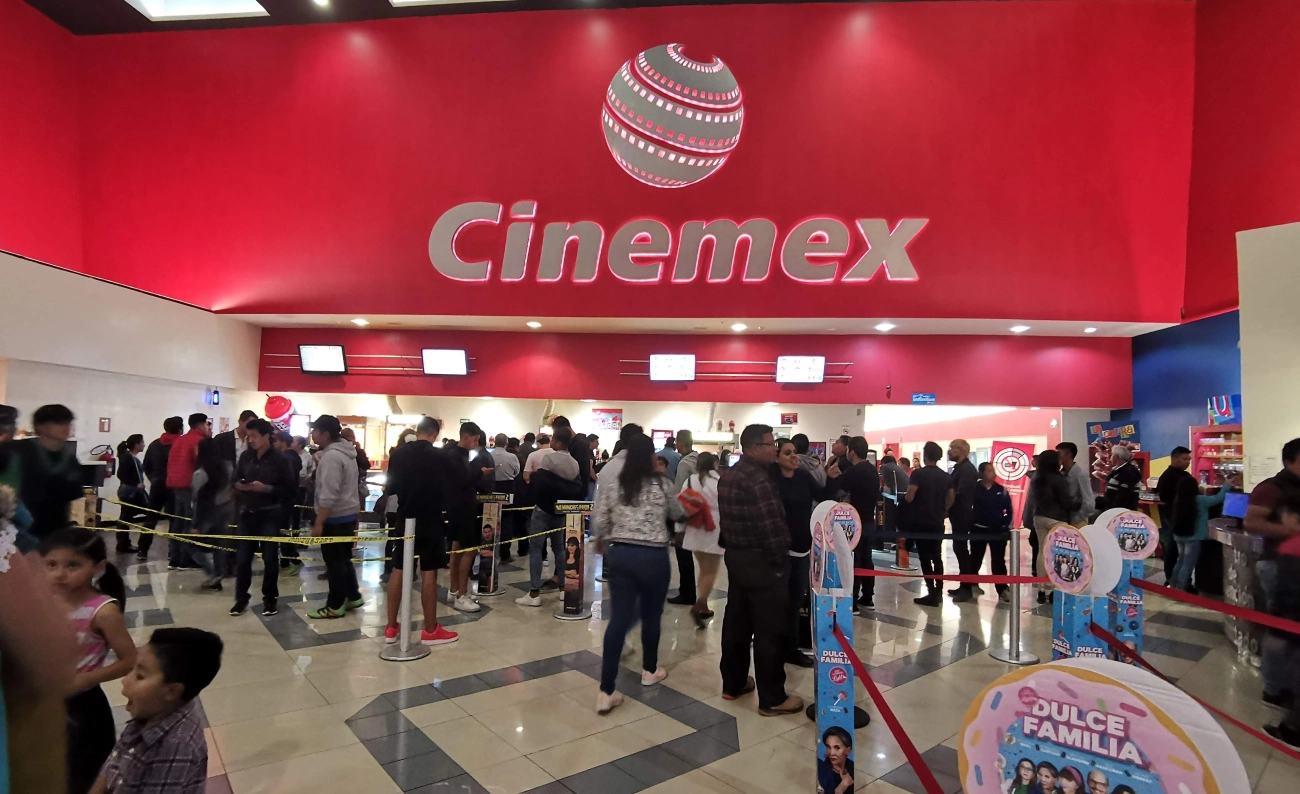 Sucursal de Cinemex en Pachuca con personas ingresando al cine por la noche.