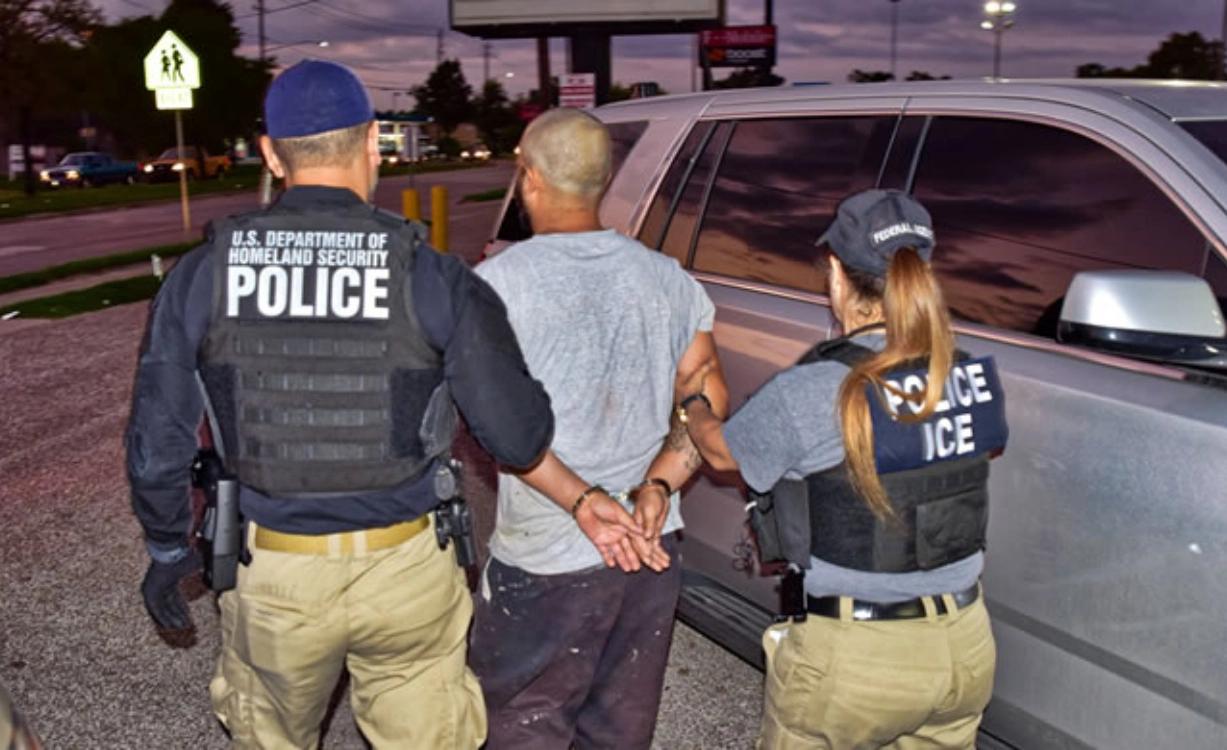 Agentes de ICE detienen a personas en operativo migratorio en zona urbana.